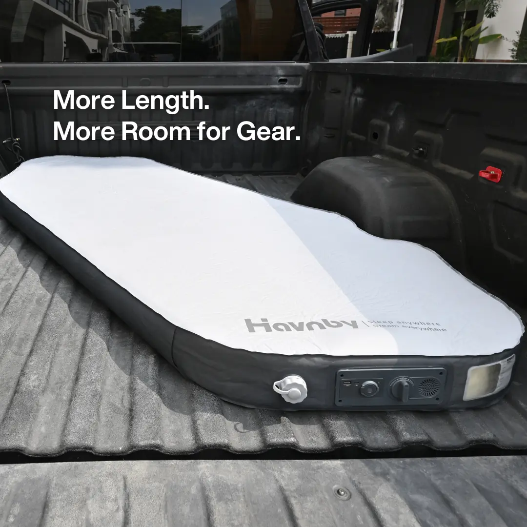 Havnby CloudCore Diagonal mattress inflated diagonally in an open pickup truck bed, with the foot-end control panel visible