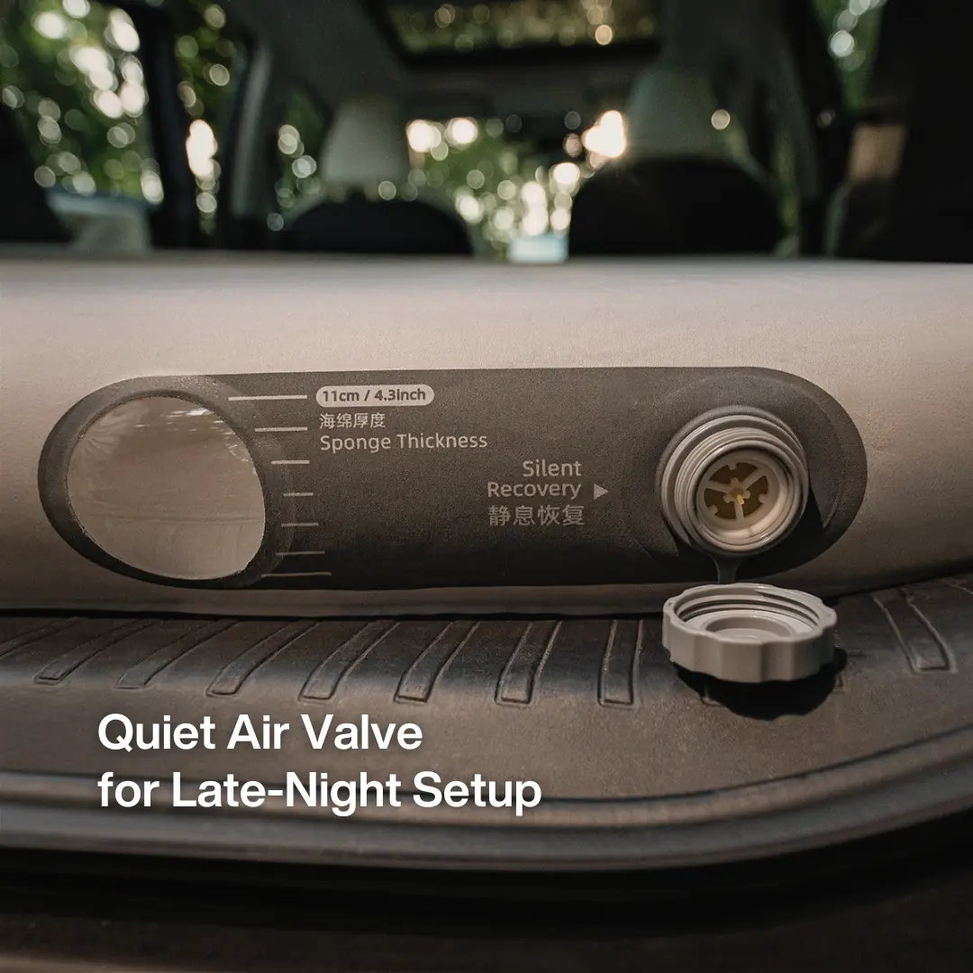 Close-up of the CloudCore SUV mattress's screw-cap air valve beside a sponge-thickness hang-tag