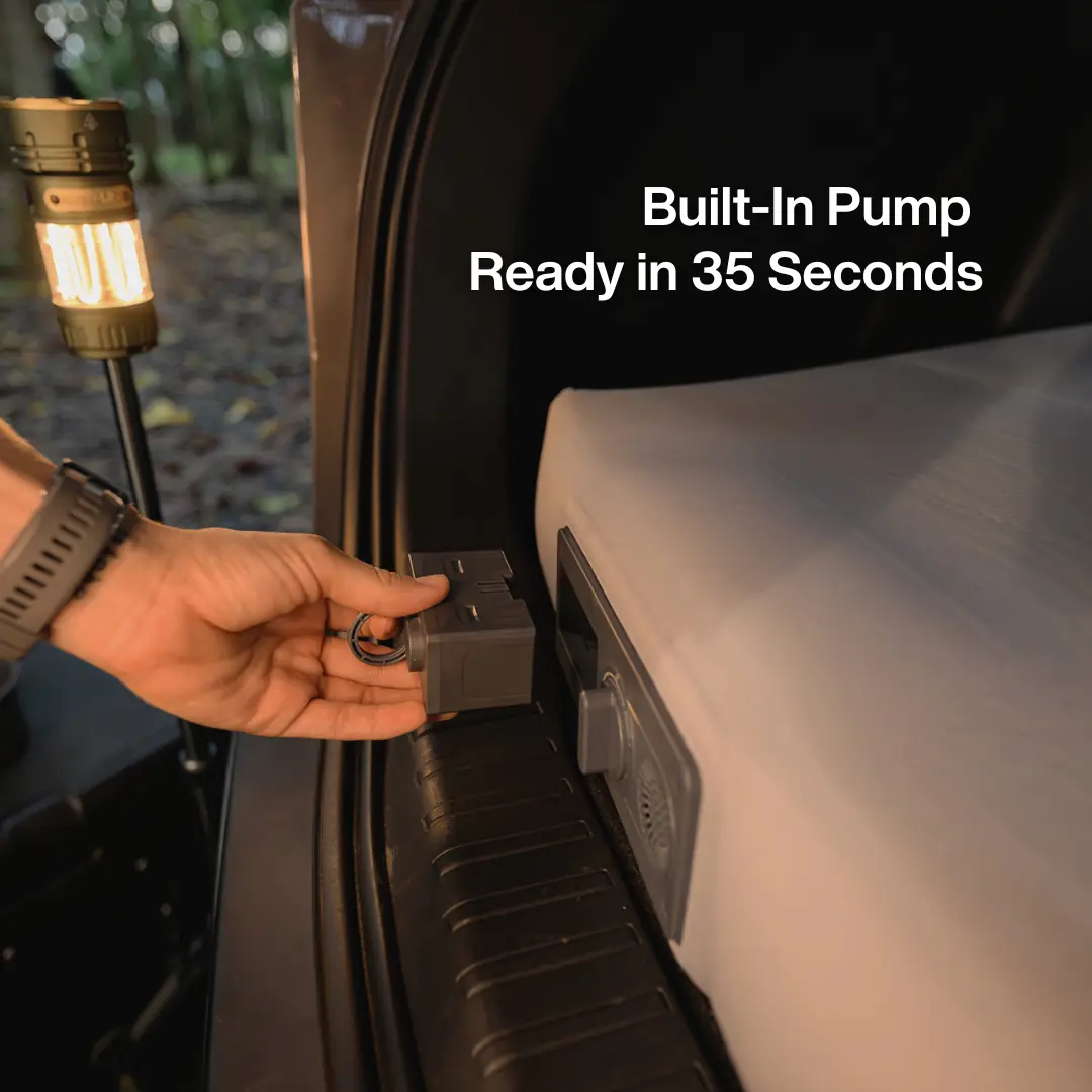A hand connecting the CloudCore SUV mattress's built-in pump power connector