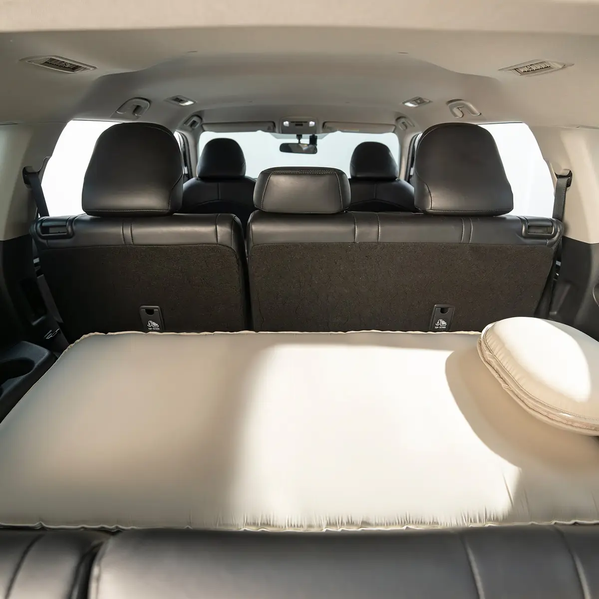 Havnby MiniNest pad inflated across the third-row cargo area of a Toyota Highlander, viewed from behind the second-row seats