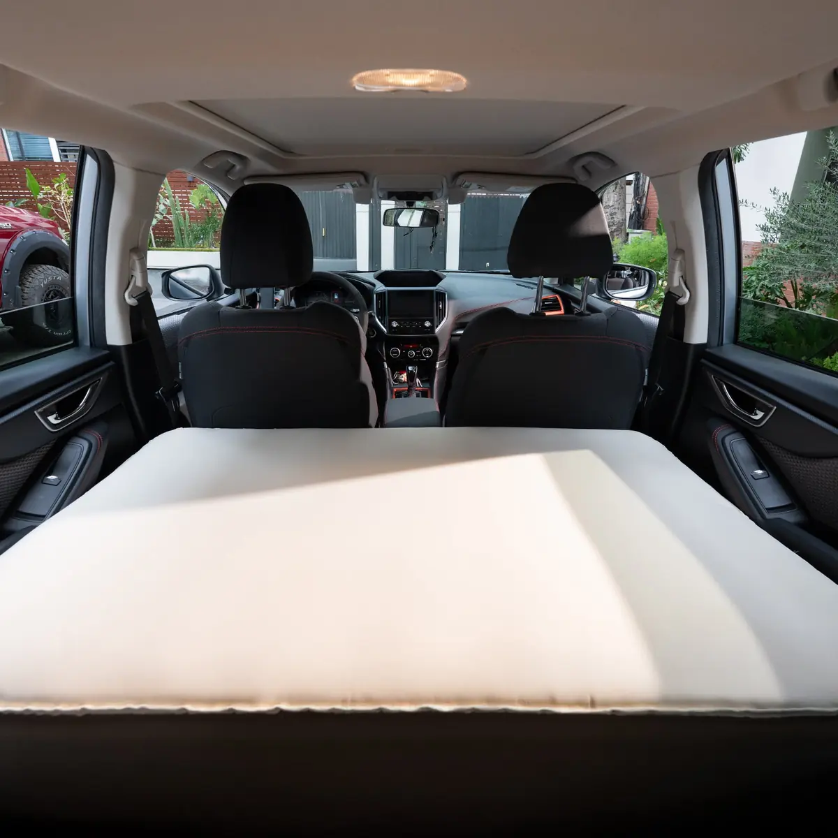 Havnby SnugNest Second-Row pad installed across a second-row vehicle seat, viewed from the cargo area