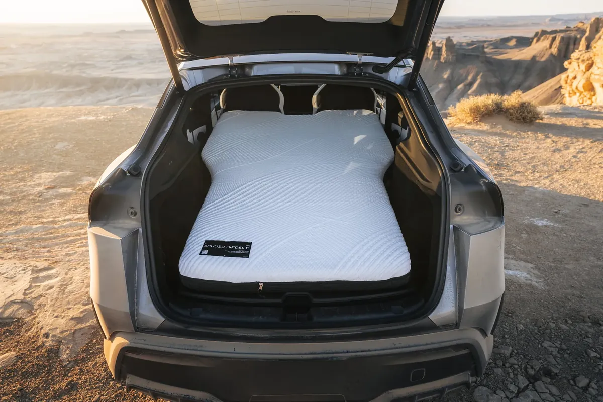 Snuuzu mattress in the open hatch of a Tesla Model Y in the desert