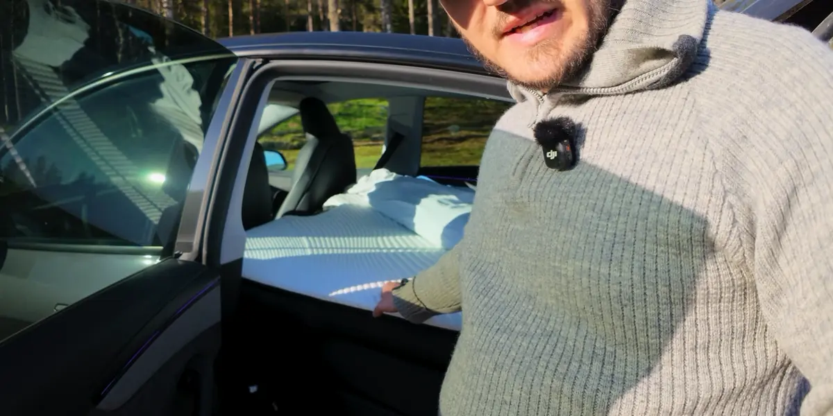 The operator standing beside the Tesla Model Y with the Snuuzu Model Y fitted in the rear