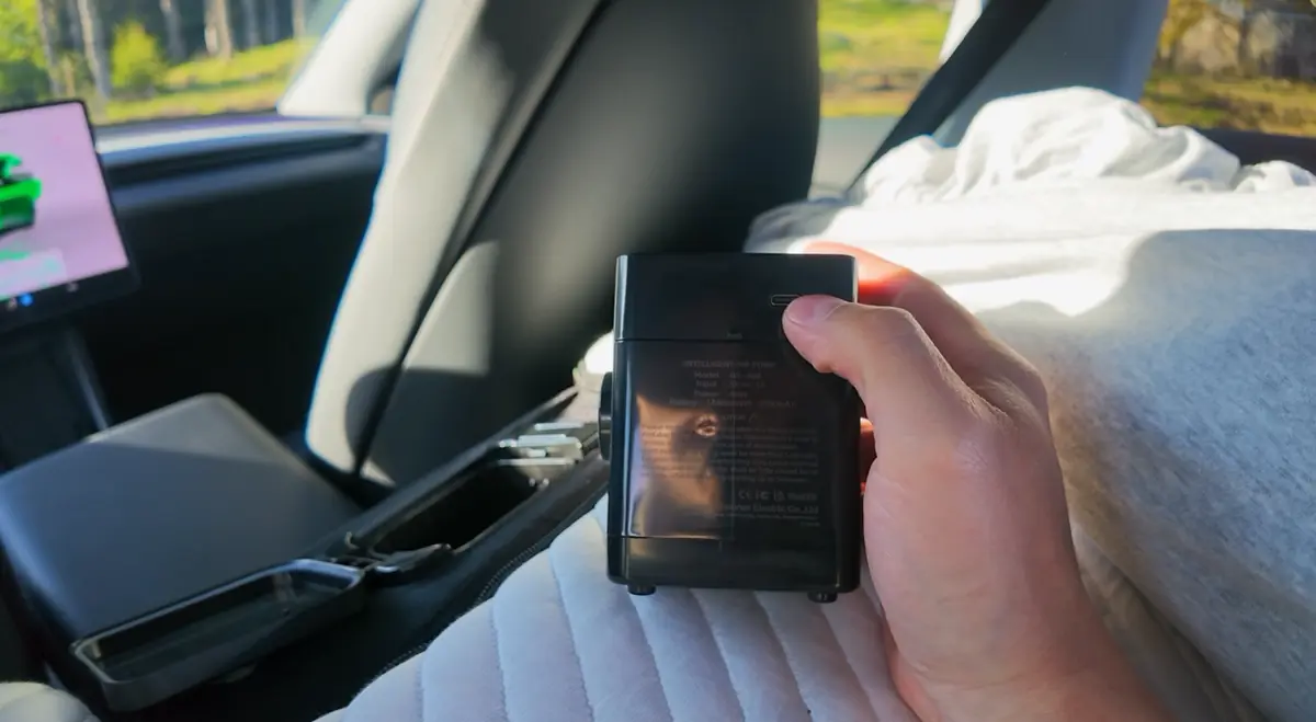 The removable Snuuzu pump held in a hand, showing its USB-C charging port